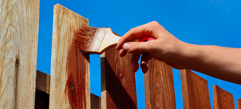 Man painting a fence.