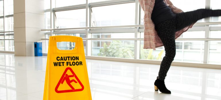 Woman slipping next to a sign.